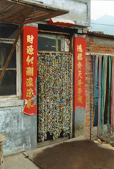 flyscreen in a shop door, made from recycled tin cans